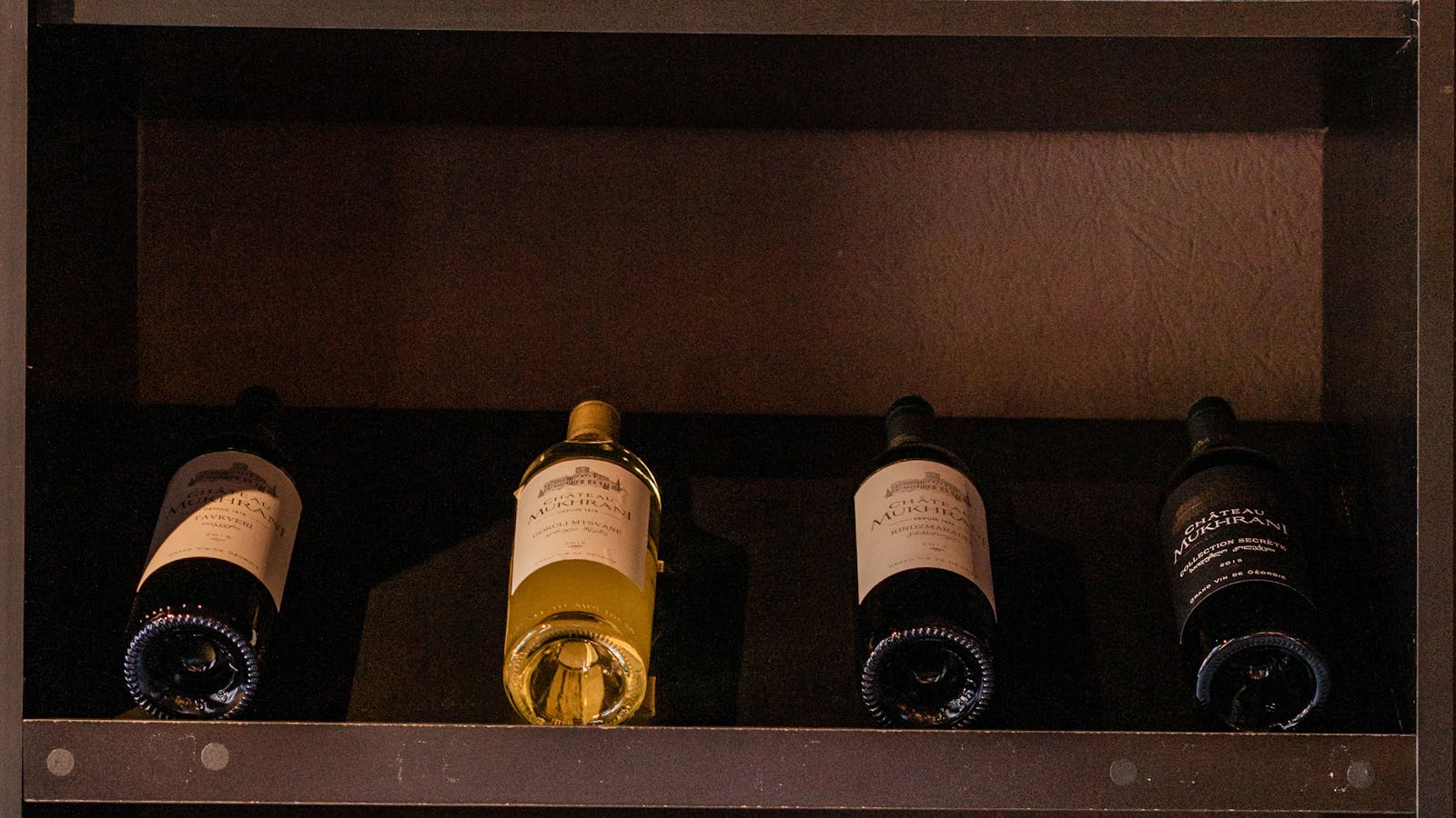 Wine bottles resting on the shelves of a wine merchant